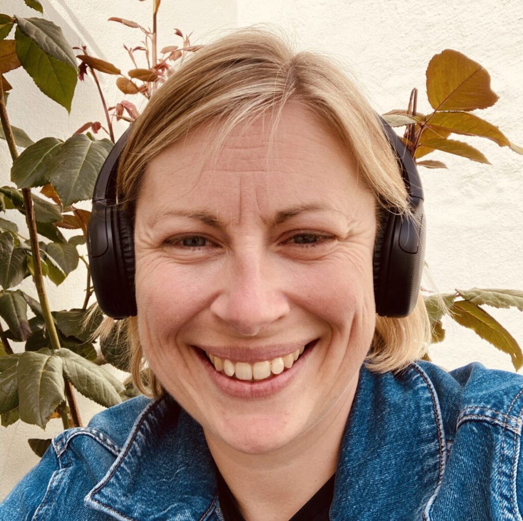 Kelly Hall wearing headphones whilst outside